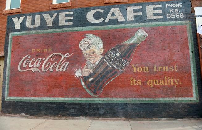 As crews removed stucco covering the exterior of a building, they found this Coca-Cola ad, which they worked to preserve. (Kathryn Scott Osler, The Denver Post)